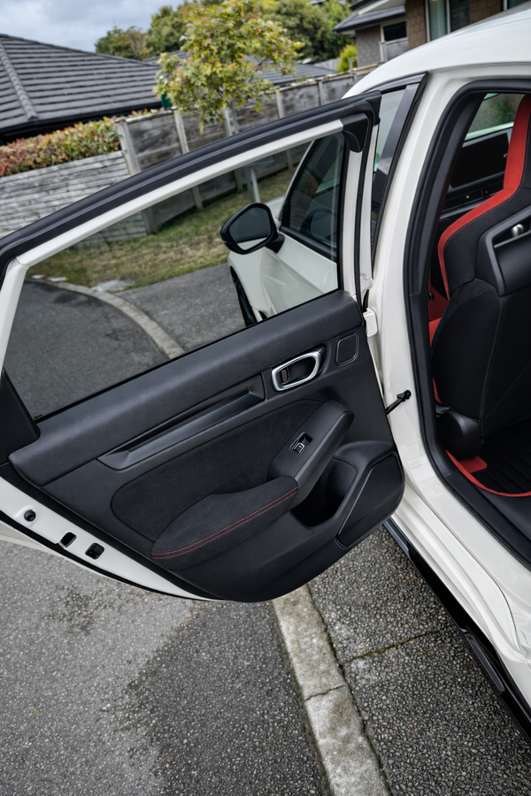 Car door open with interior view, parked outdoors.